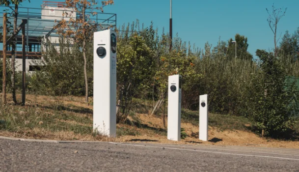 Parc de bornes de recharge Nexteneo situées à l'extérieur, illustrant le réseau électrique auquel Nexteneo participe en Savoie