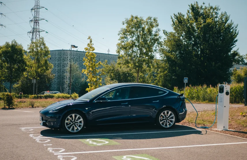 Voiture hybride en cours de recharge sur une station de recharges Nexteneo, sur une place réservée aux véhicules rechargeables