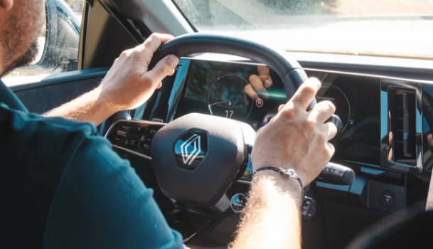 Homme au volant d'une voiture intelligente électrique, le cadran montre la consommation énergétique du véhicule