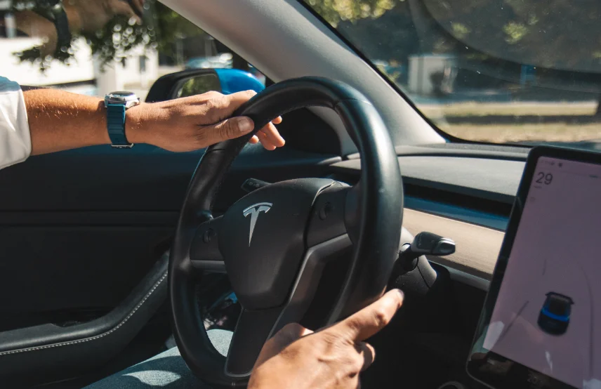 Homme qui conduit un véhicule électrique après un rechargement sur une borne de recharge Nexteneo