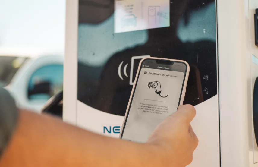 Utilisateur de l'application mobile qui utilise le logiciel de supervision à proximité d'une borne de recharge Nexteneo