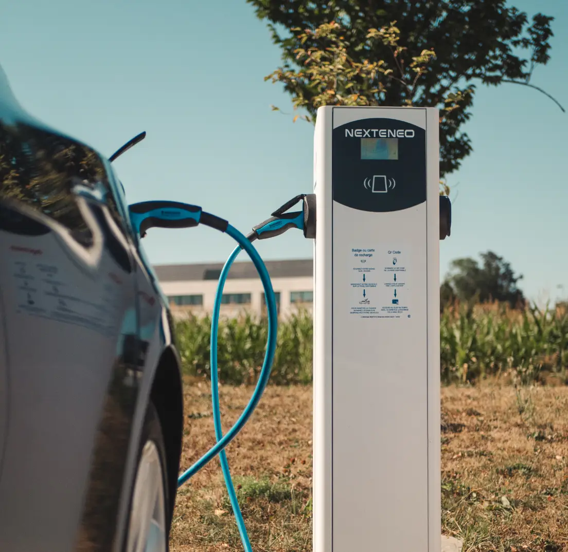 Véhicule électrique en train de se recharger à l'aide d'une borne Nexteneo sur un parc de bornes électriques. La technologie Ingeteam est mise en évidence sur la borne.