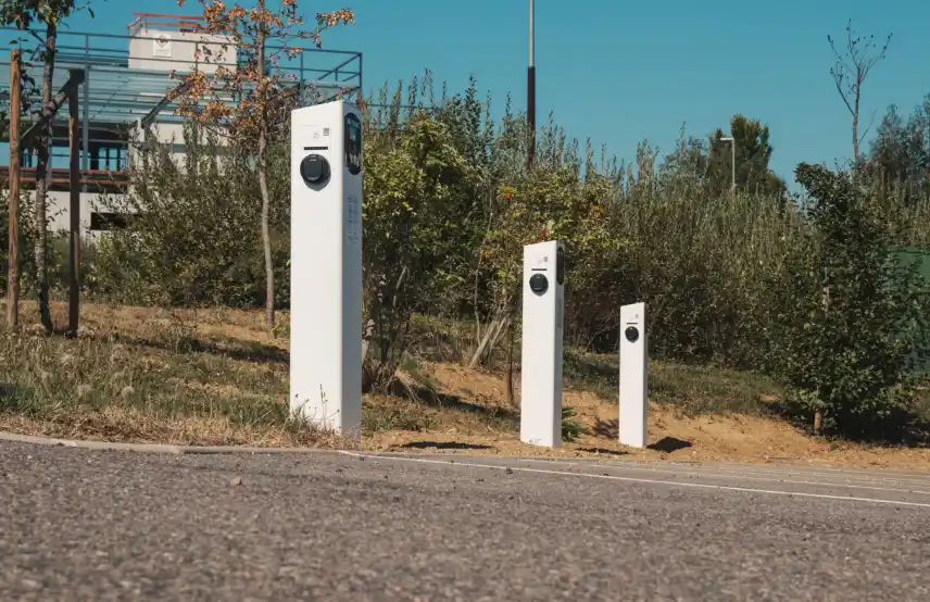 Parc de bornes de recharge Nexteneo situées à l'extérieur, illustrant le réseau électrique auquel Nexteneo participe en Savoie